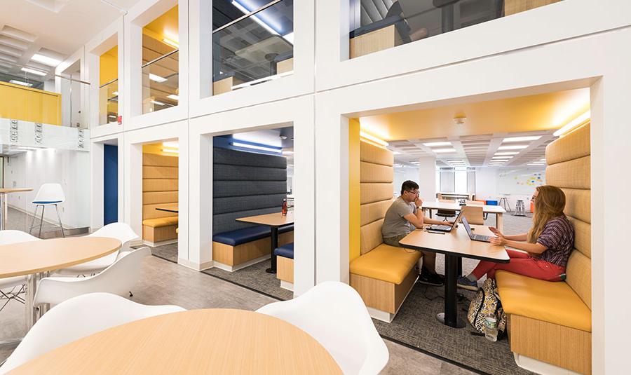 students sitting at brightly lit iZone tables.